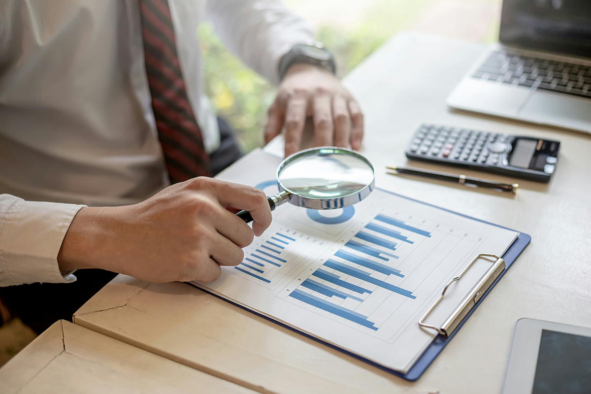 Financial analysis and due diligence review with magnifying glass